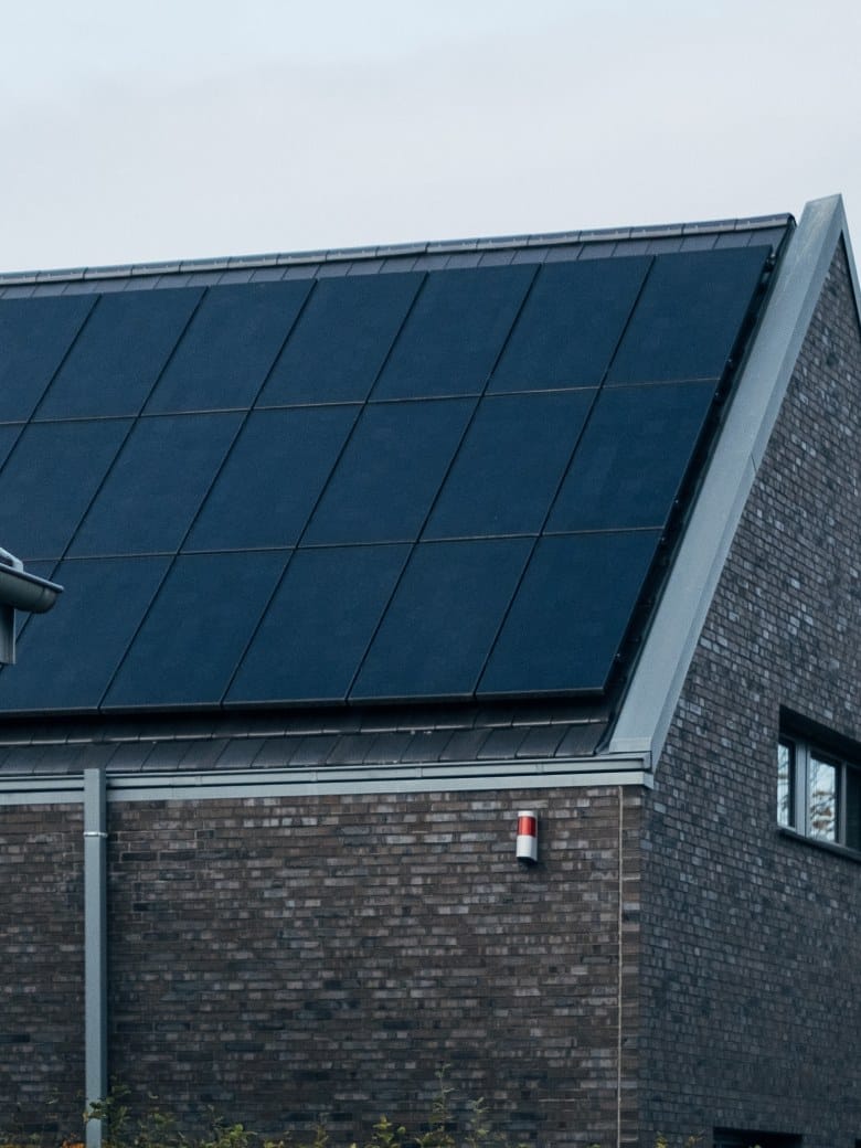 Brick house with a roof covered in black solar panels