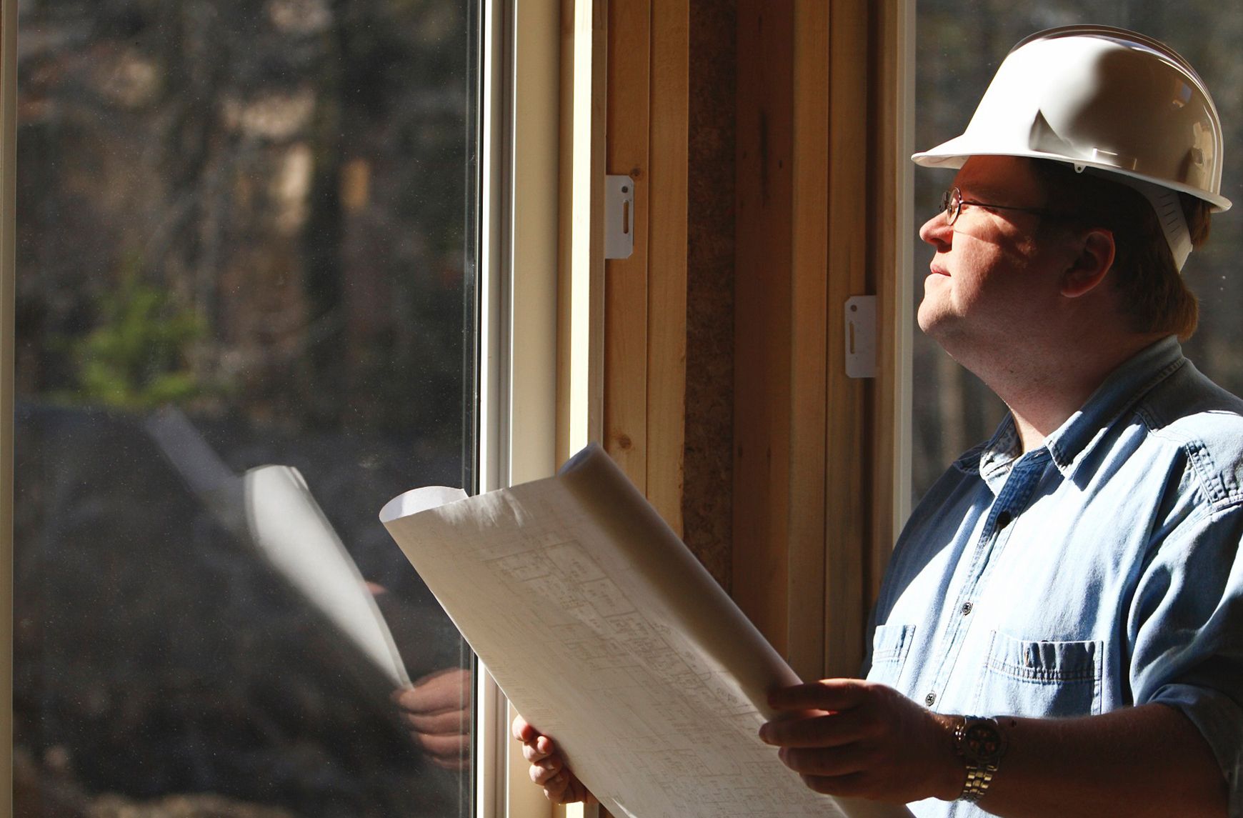 Tyrrells building consultant in a hard hat reviewing plans