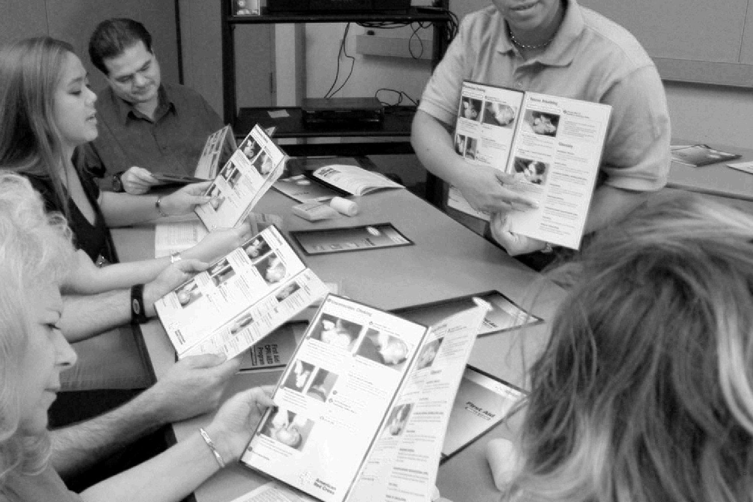 American Red Cross first aid class reviewing course booklets with an instructor