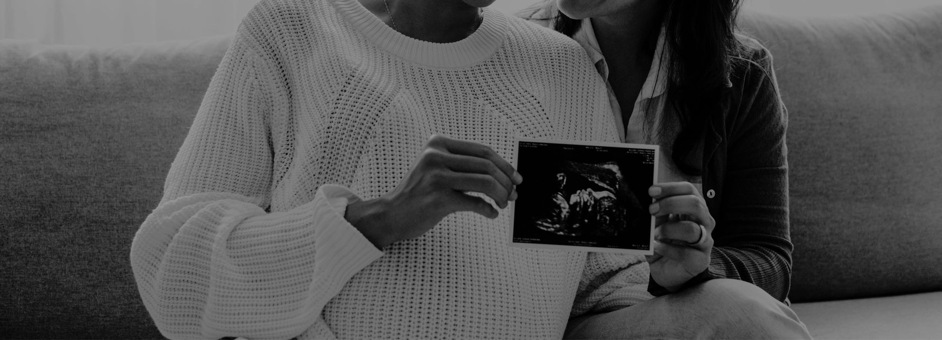 Hands holding an ultrasound scan print