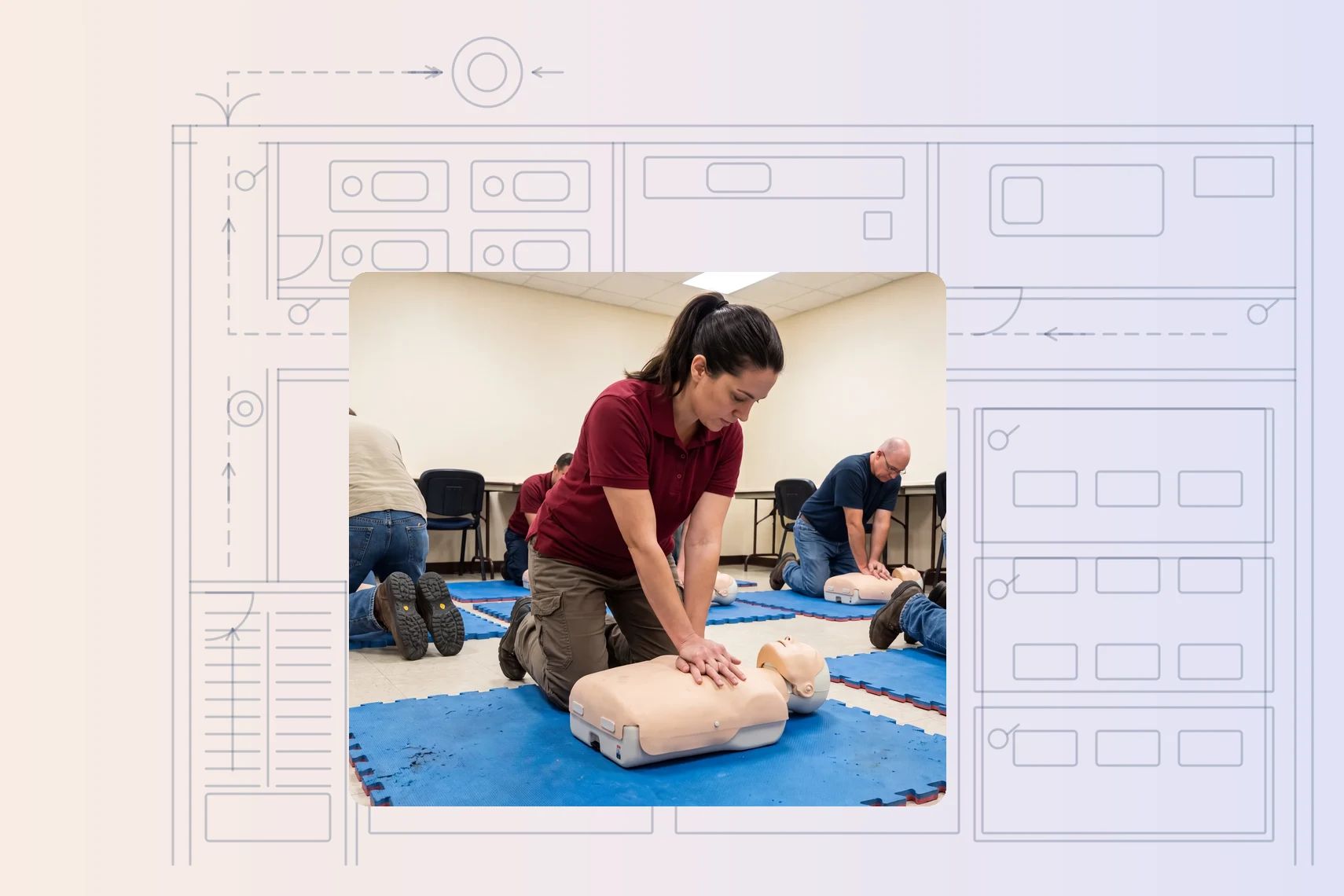 Trainer mid-compression on CPR manikin, trainees copying at their own manikins