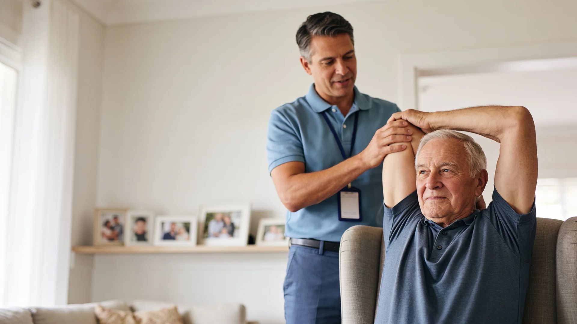 Physiotherapist coaching elderly man through arm stretches at home