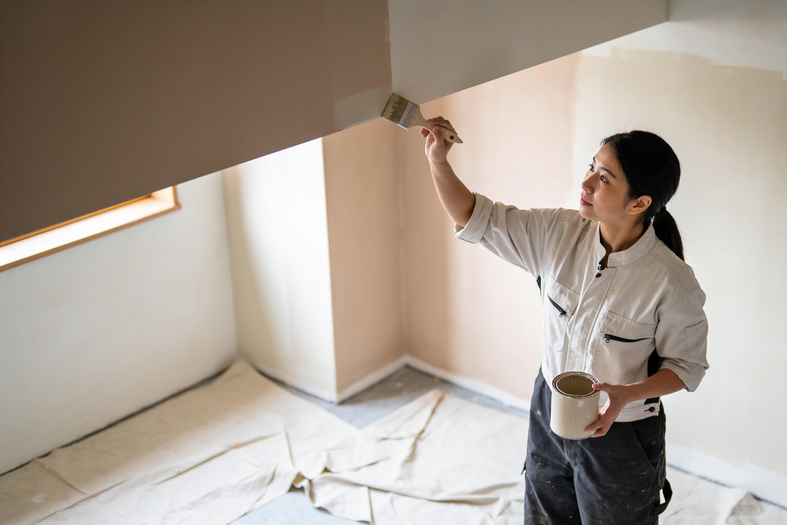 Painter cutting in a wall edge in a customer's room